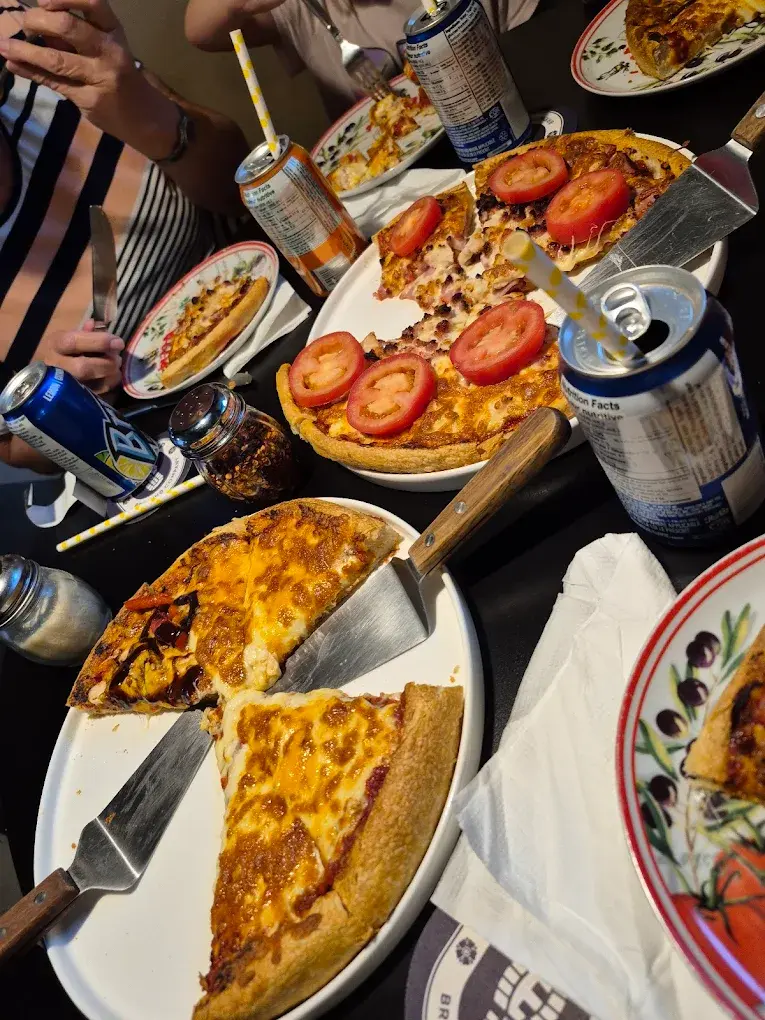 Family pizza night around a shared table at DJ's Pizzeria & Lounge in St. Albert, AB
